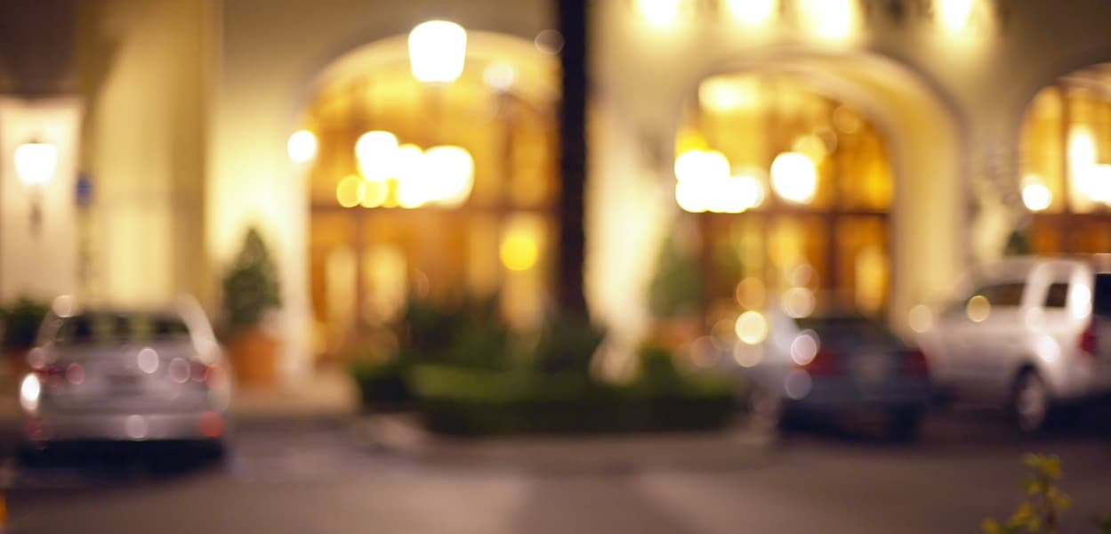 Blurred image of upmarket house and cars